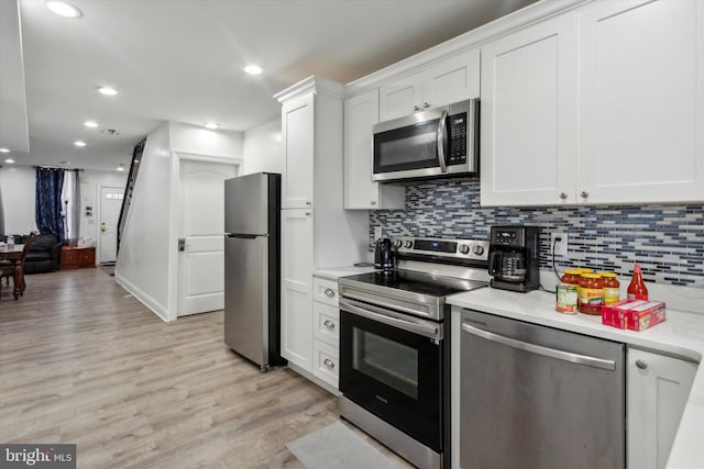 kitchen featuring light hardwood / wood-style floors, white cabinetry, stainless steel appliances, and tasteful backsplash