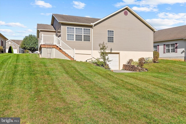 back of property featuring a garage and a yard