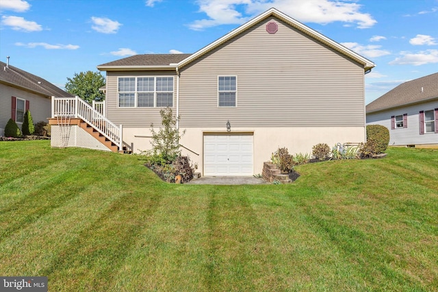 rear view of property featuring a garage and a yard