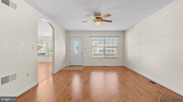 entrance foyer with light hardwood / wood-style flooring and ceiling fan with notable chandelier