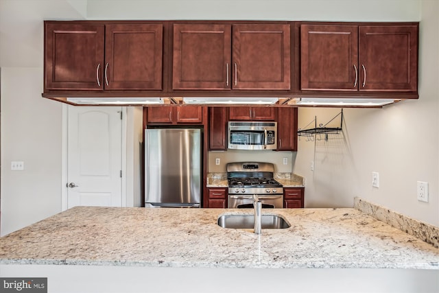 kitchen featuring stainless steel appliances and light stone counters