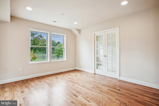 spare room with light hardwood / wood-style floors and french doors