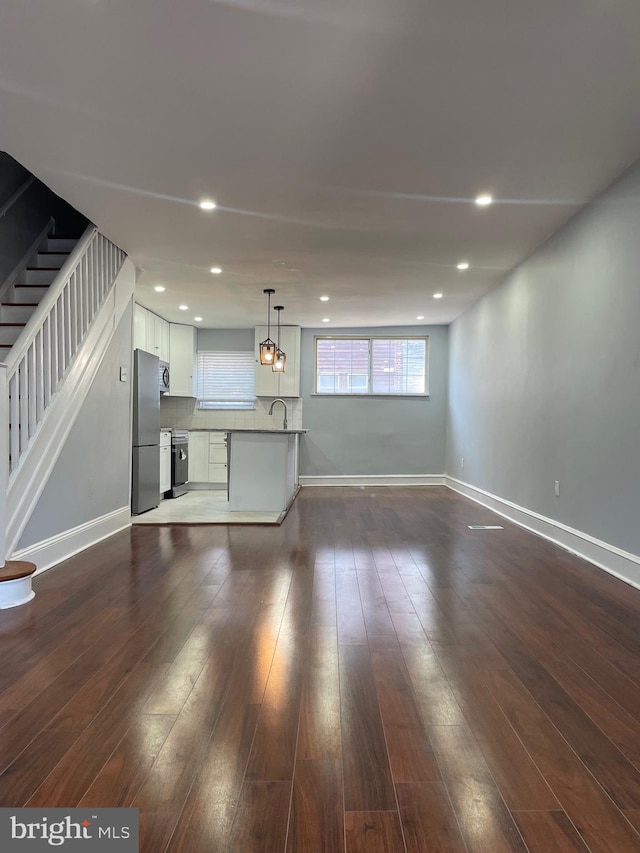 unfurnished living room featuring dark hardwood / wood-style floors and sink