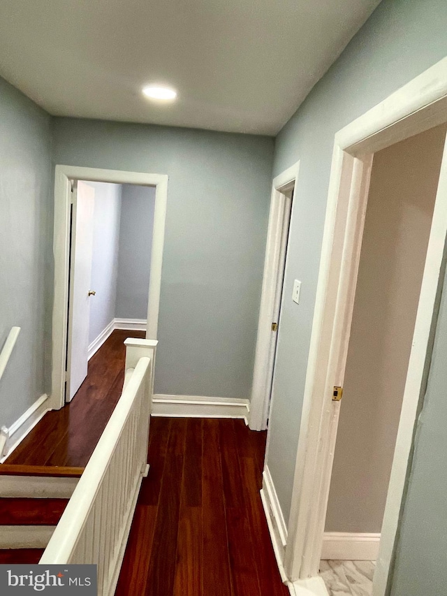 hallway with dark hardwood / wood-style flooring