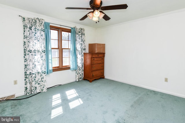 carpeted empty room with ceiling fan and crown molding