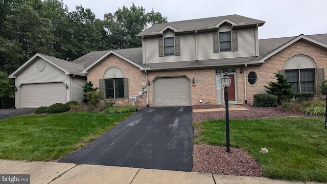 view of property featuring a garage and a front lawn