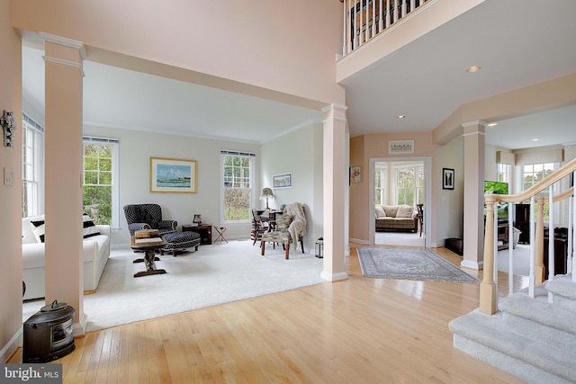 entryway with decorative columns, light hardwood / wood-style flooring, plenty of natural light, and ornamental molding