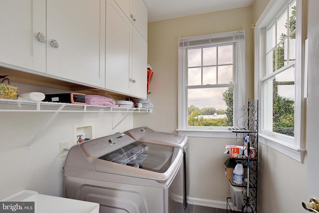 laundry room featuring washer and dryer and cabinets