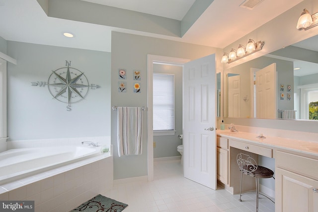 bathroom with vanity, tiled bath, a healthy amount of sunlight, and toilet