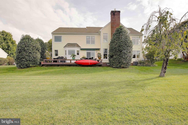 back of property with central air condition unit and a yard