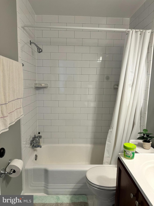 full bathroom featuring shower / tub combo with curtain, vanity, and toilet