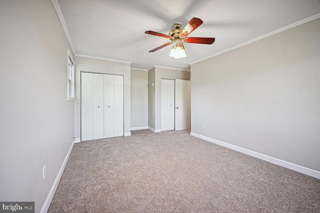 unfurnished bedroom with a textured ceiling, carpet, ceiling fan, and crown molding