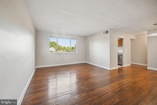 empty room featuring a textured ceiling and dark wood-type flooring