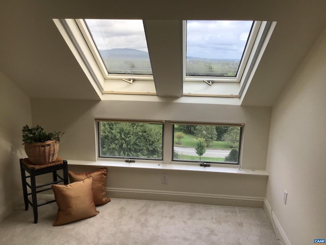 sitting room with light colored carpet and a skylight