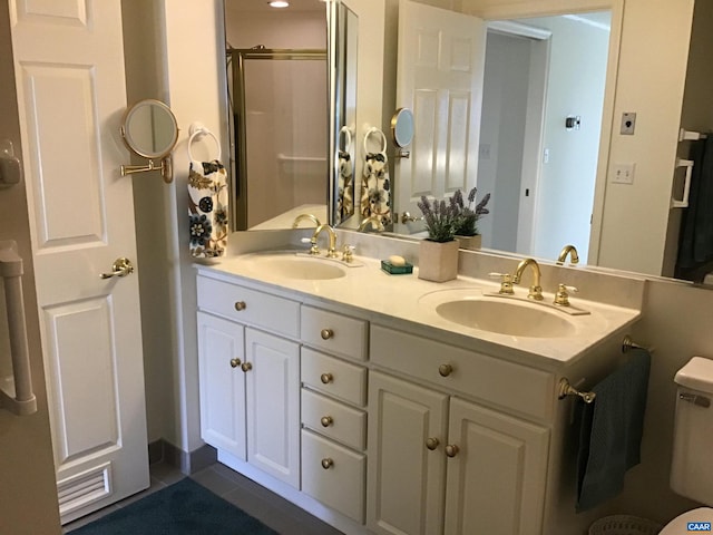 bathroom featuring vanity, walk in shower, toilet, and tile patterned floors