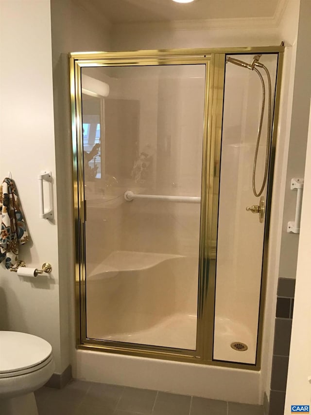 bathroom with toilet, walk in shower, and tile patterned flooring