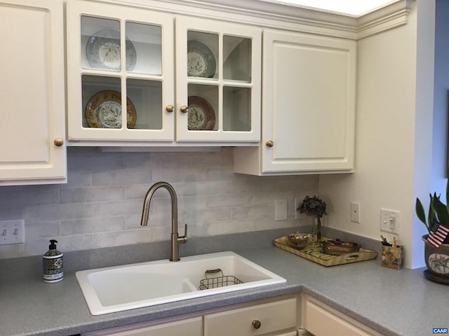 kitchen with white cabinetry, tasteful backsplash, and sink