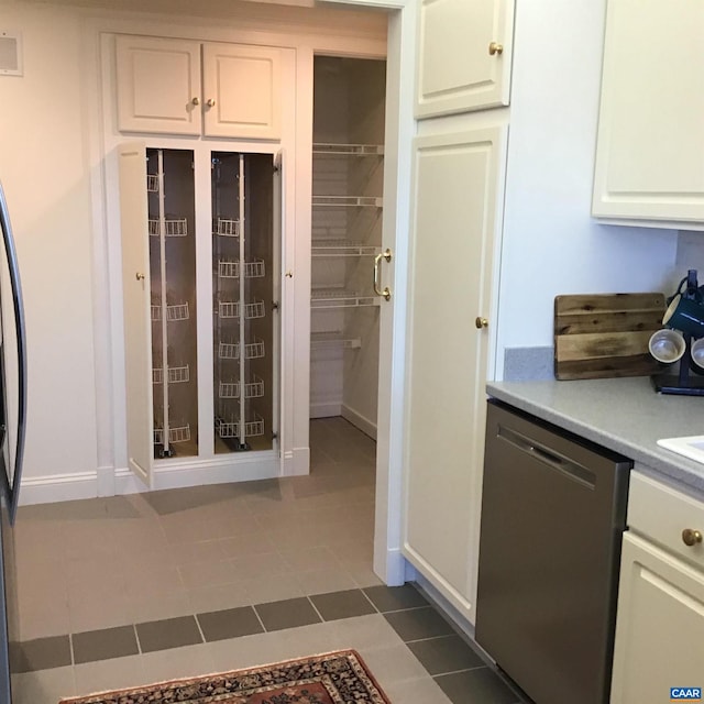 kitchen featuring dishwasher, white cabinetry, and light tile patterned floors