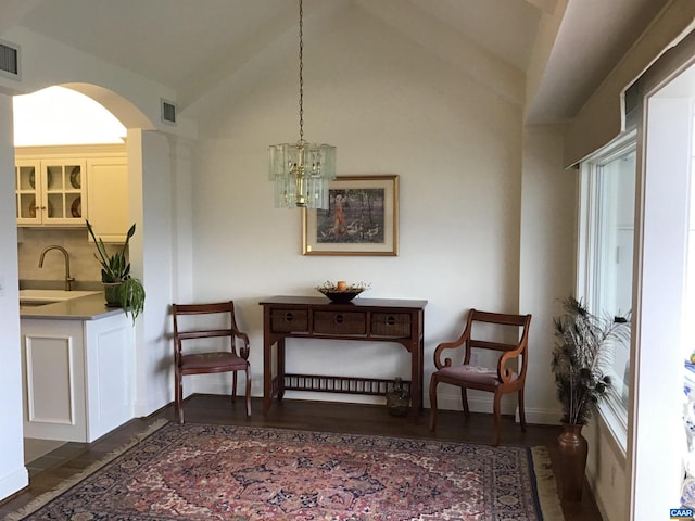 living area featuring sink, vaulted ceiling, a chandelier, and dark hardwood / wood-style flooring