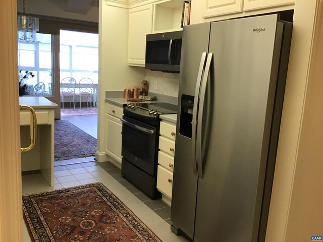 kitchen featuring white cabinets, stainless steel appliances, and tile patterned flooring