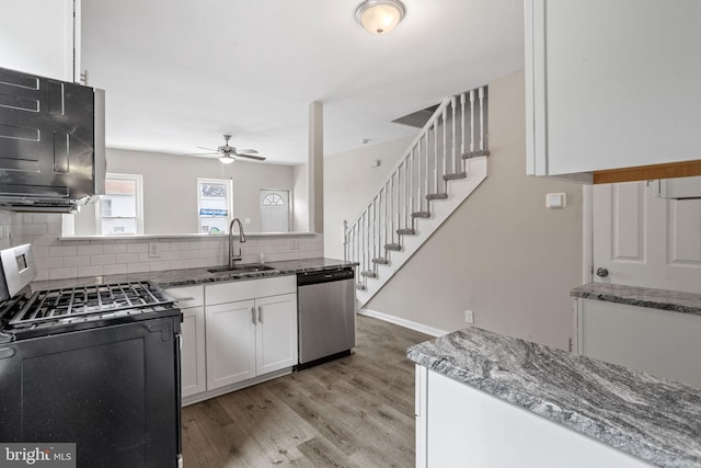 kitchen featuring white cabinets, sink, tasteful backsplash, light hardwood / wood-style flooring, and stainless steel appliances