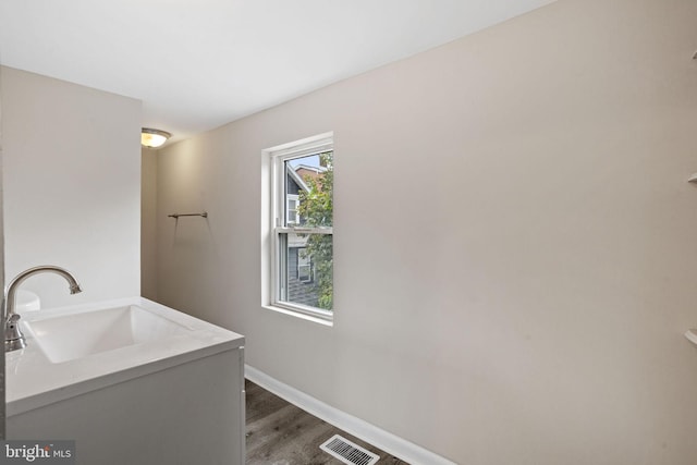 laundry room featuring dark hardwood / wood-style floors and sink