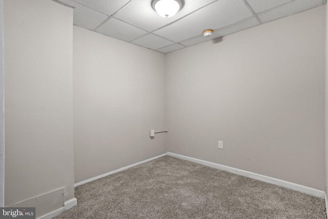 carpeted empty room with a paneled ceiling