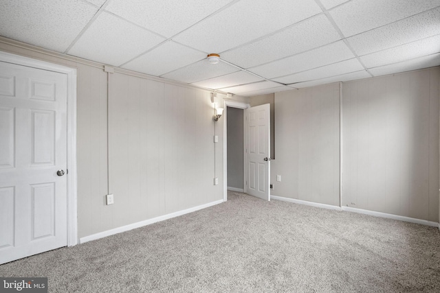 empty room featuring carpet flooring and a paneled ceiling