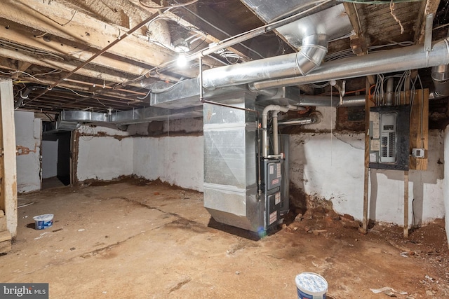 basement featuring electric panel and heating unit