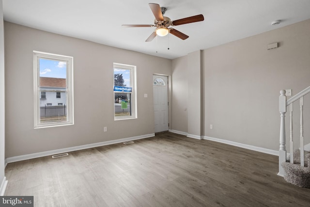 spare room with a healthy amount of sunlight, ceiling fan, and wood-type flooring