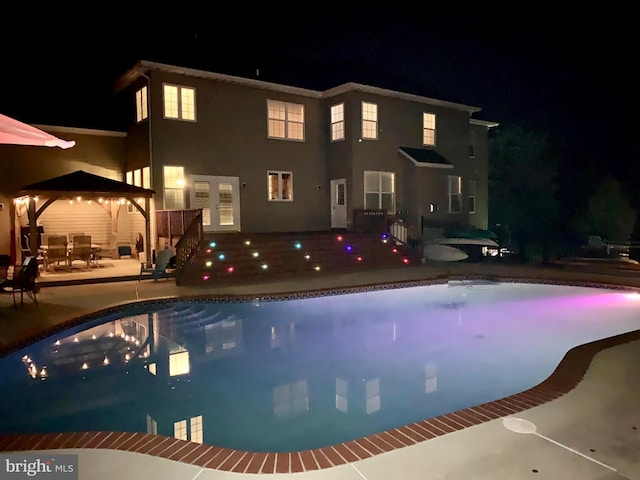 pool at night with a patio area