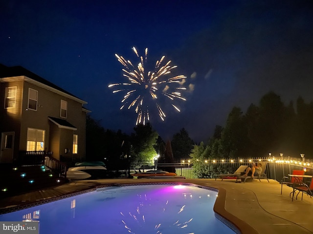 pool at night with a patio area