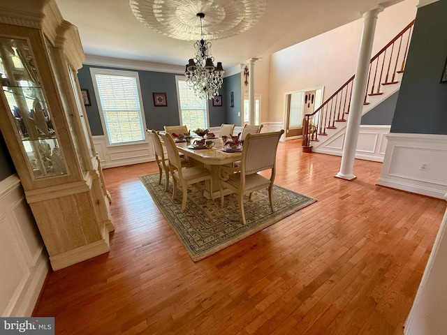 dining area with light hardwood / wood-style floors, an inviting chandelier, and crown molding