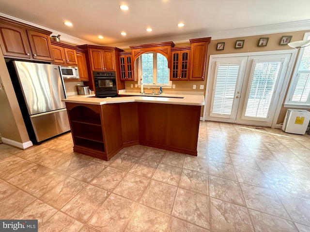 kitchen with oven, a kitchen island, crown molding, and stainless steel refrigerator