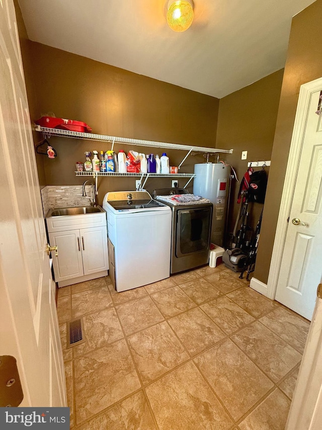 clothes washing area with cabinets, electric water heater, washer and dryer, light tile patterned flooring, and sink