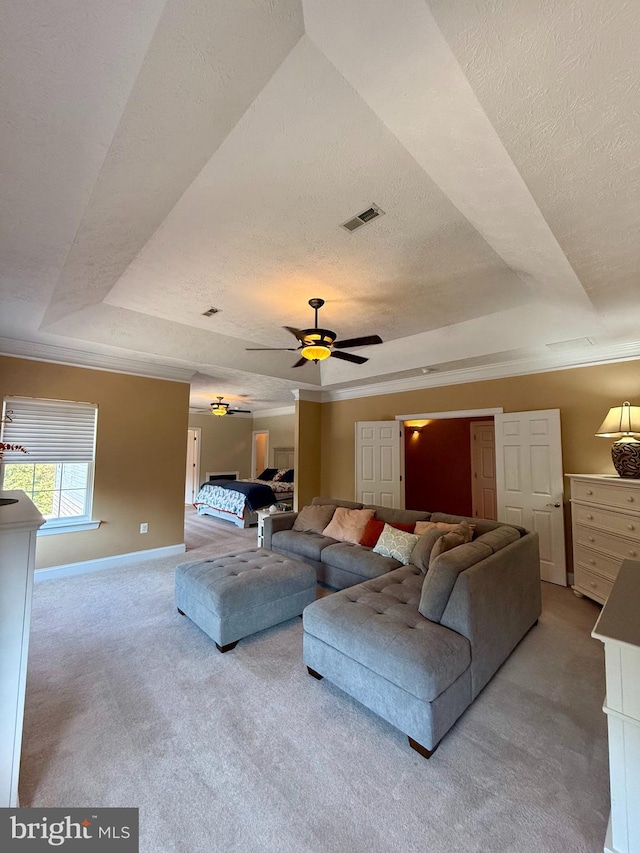 carpeted living room featuring crown molding, a tray ceiling, a textured ceiling, and ceiling fan