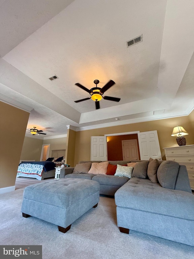 carpeted living room with ceiling fan, a textured ceiling, and a raised ceiling