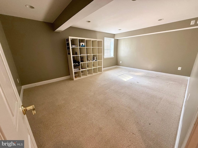 spare room featuring beamed ceiling and carpet floors