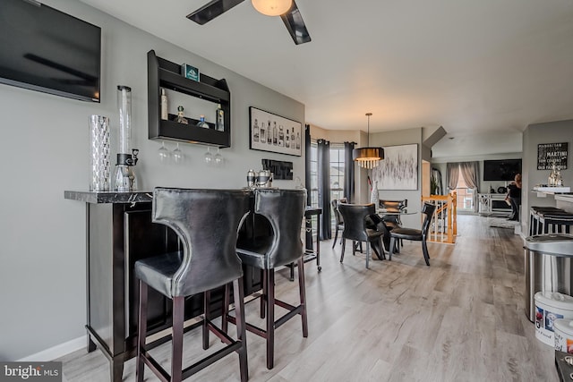 bar featuring light hardwood / wood-style flooring and decorative light fixtures