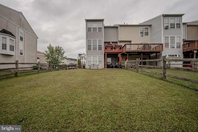 rear view of property featuring a lawn and a deck