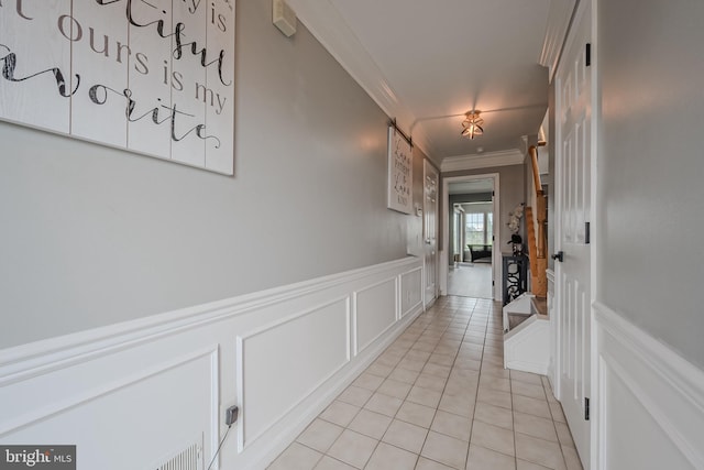 hall with light tile patterned floors and ornamental molding