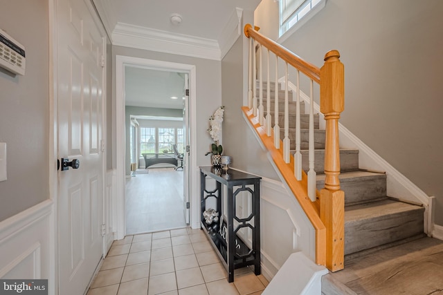 staircase featuring crown molding and tile patterned floors