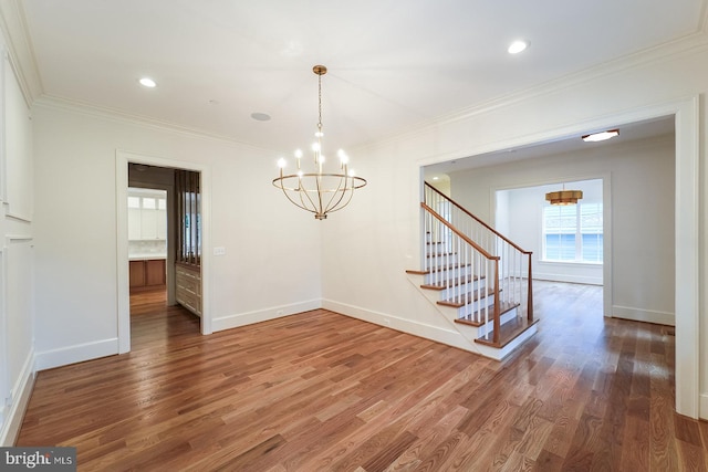 unfurnished room with a chandelier, dark wood-type flooring, and crown molding