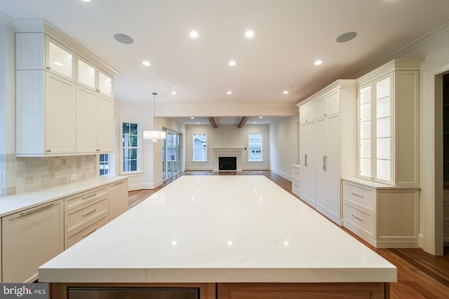 kitchen with a large island, decorative light fixtures, and hardwood / wood-style flooring