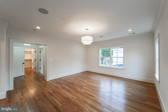 spare room featuring hardwood / wood-style flooring and crown molding