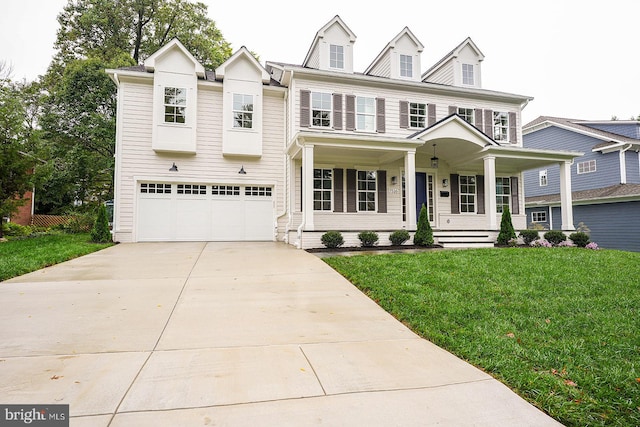 view of front of home with a garage, covered porch, and a front yard