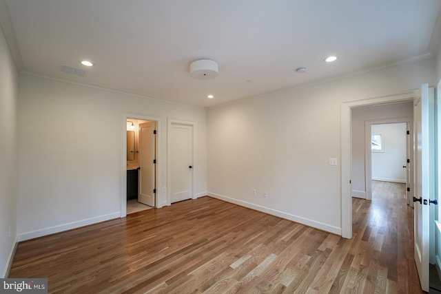 spare room featuring ornamental molding and light hardwood / wood-style floors