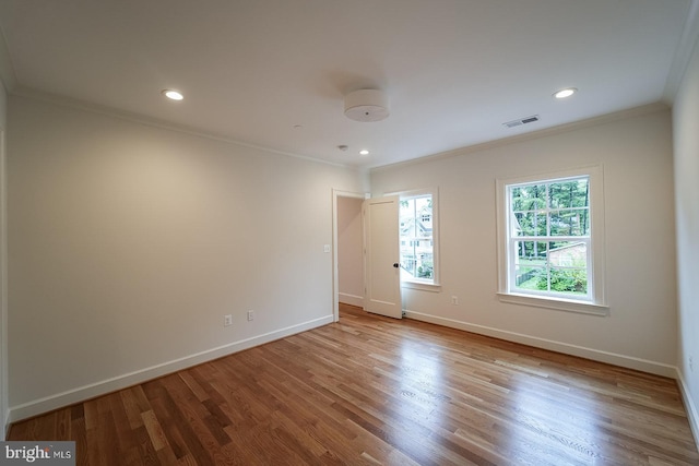 empty room featuring ornamental molding and light hardwood / wood-style flooring