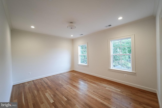 unfurnished room with light wood-type flooring and crown molding