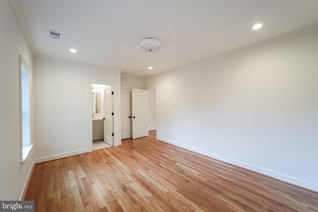 unfurnished bedroom with connected bathroom, ornamental molding, and light hardwood / wood-style flooring